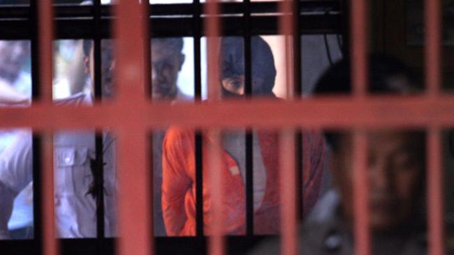 Lamar Aaron Ahchee is pictured being escorted back to the cell after speaking to his mother in an interrogation room on Wednesday. Picture: Lukman S. Bintoro