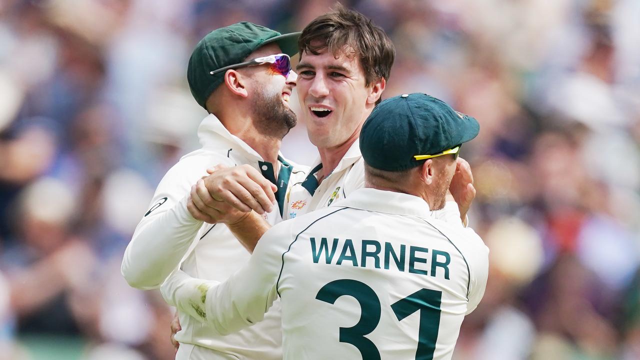 Pat Cummins of Australia (centre) celebrates a wicket with Nathan Lyon and David Warner (AAP Image/Michael Dodge)