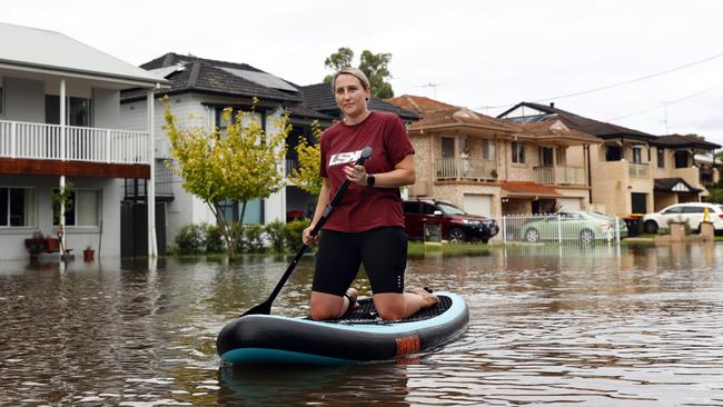 South Windsor resident Lauren Smith has resorted to paddle boarding down her street. Picture: Richard Dobson