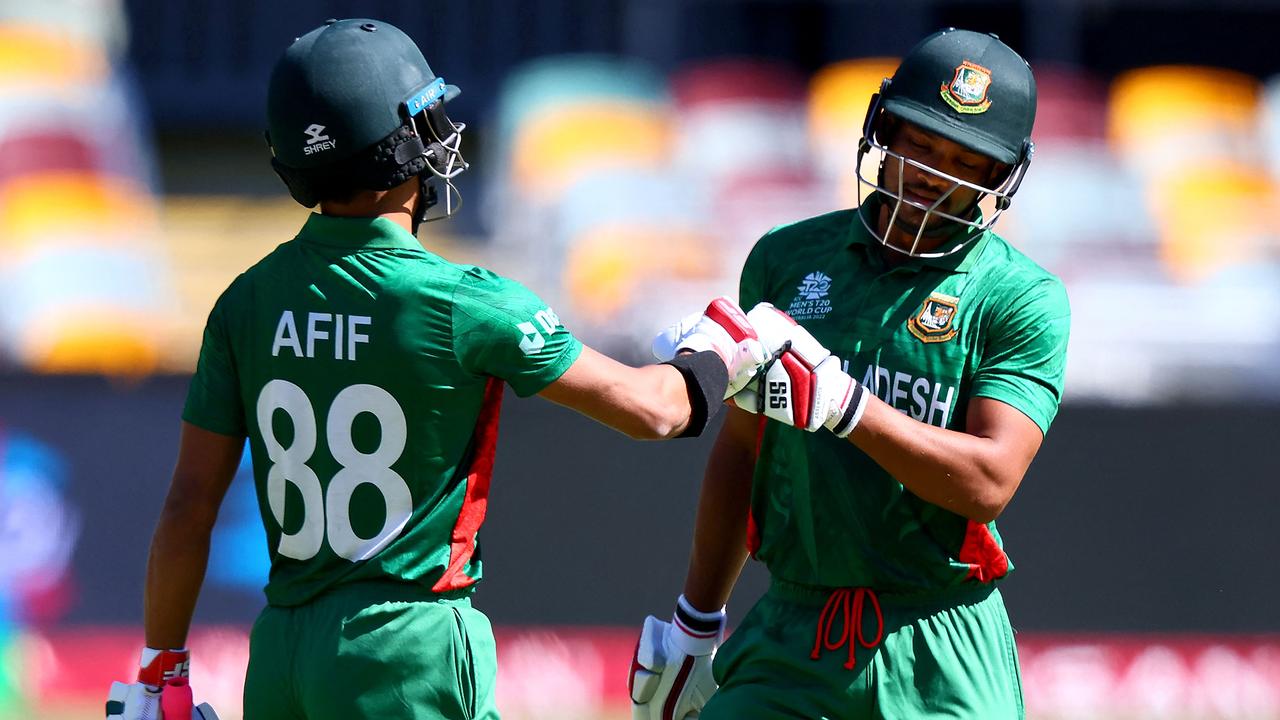 Afif Hossain (L) bumps glove with Najmul Hossain Shanto (R) as he walks off the field after his dismissal. (Photo by Patrick HAMILTON / AFP)