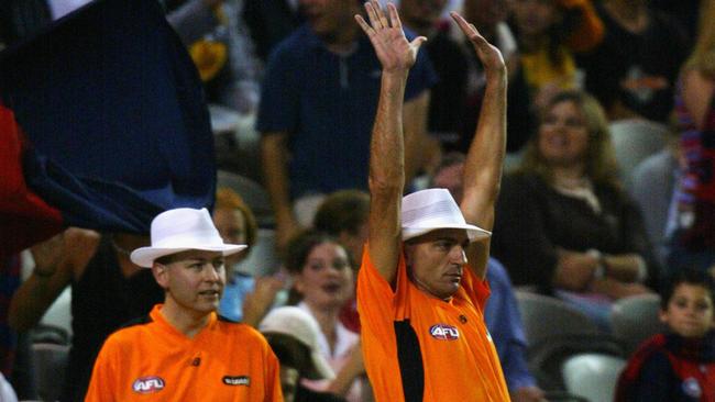 An AFL goal umpire signals a SuperGoal.