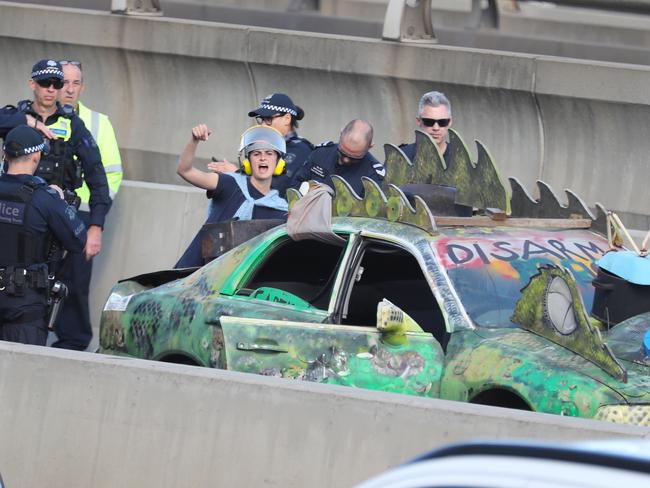 A pro-Palestine activist chained herself to a car near a Melbourne freeway in protest against the upcoming Land Forces expo. Picture: David Crosling