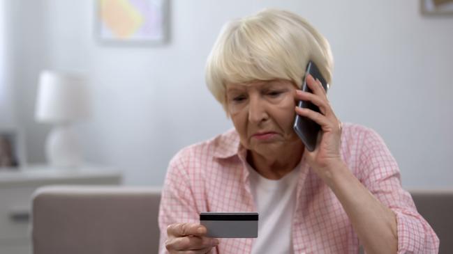 Sad old woman with credit card calling bank support, reporting about money fraud istock image