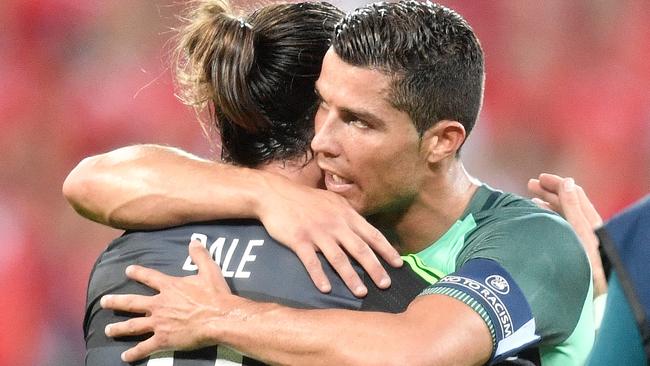 Wales' Gareth Bale, left, and Portugal's Cristiano Ronaldo embrace each other.