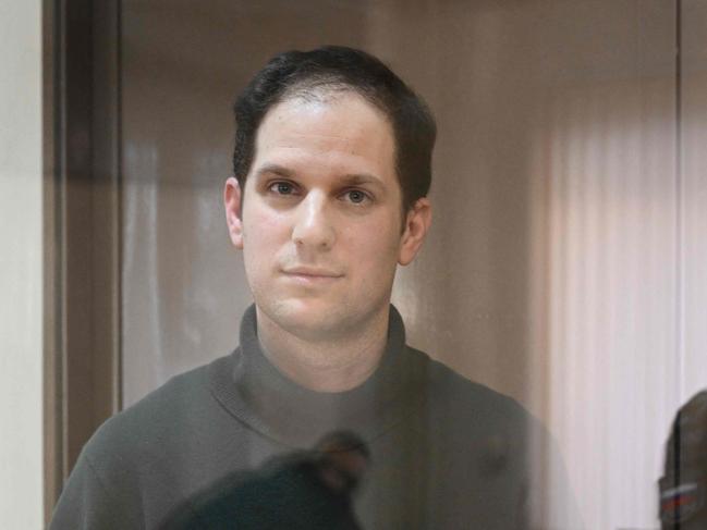 TOPSHOT - US journalist Evan Gershkovich, arrested on espionage charges, stands inside a defendants' cage before a hearing to consider an appeal on his extended pre-trial detention, at the Moscow City Court in Moscow on February 20, 2024. Wall Street Journal reporter Evan Gershkovich was detained last March on spying charges during a reporting trip to the Urals. (Photo by NATALIA KOLESNIKOVA / AFP)