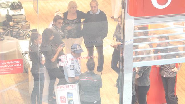 Customers at Vodafone near the scene of the shooting at Robina Town Centre, Gold Coast, in April 2012.