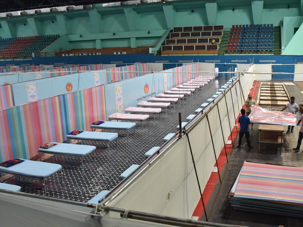 Workers arrange beds to prepare a COVID-19 care centre inside the Sarusajai Sports Complex in Guwahati, as officials brace for “disaster”. Picture: AFP