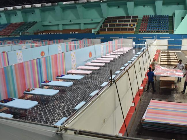 Workers arrange beds to prepare a COVID-19 care centre inside the Sarusajai Sports Complex in Guwahati, as officials brace for “disaster”. Picture: AFP