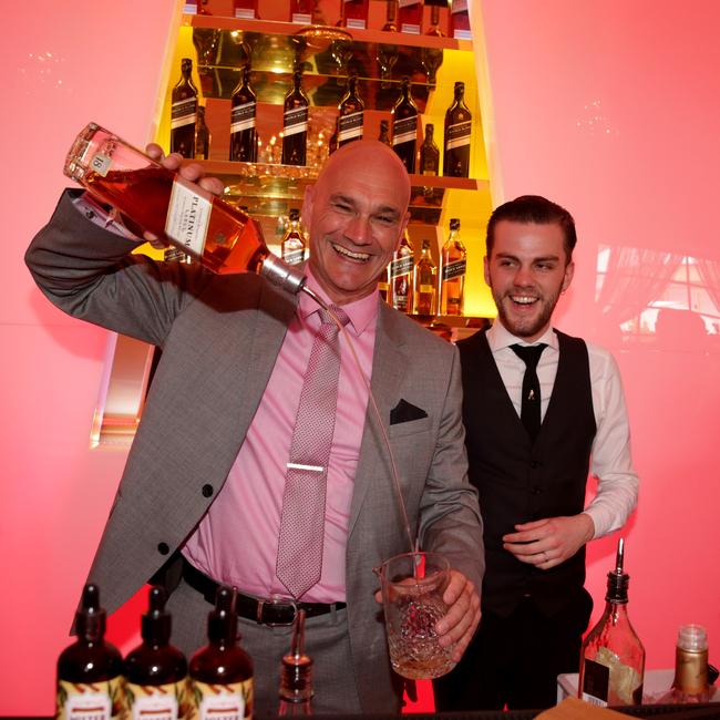 Tim Salt, the managing director of drinks company, Diageo behind the bar at the Johnnie Walker marquee on 2014 Melbourne Cup Day, Flemington.