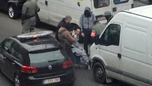 A man believed to be connected to a key suspect in the November 2015 Paris attacks Salah Abdeslam, is detained by police during a raid in Brussels.