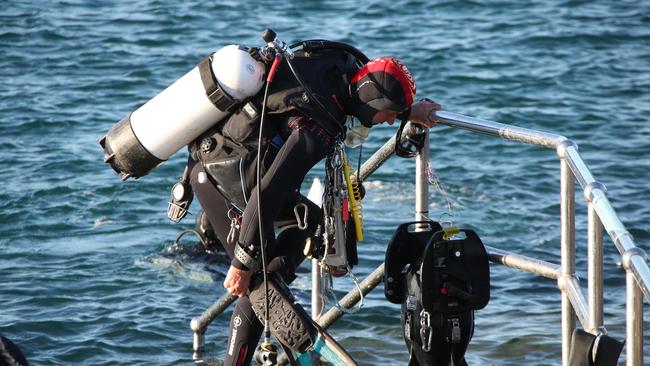 A friend of the deceased helps police search the Southport Seaway for a weight belt that belonged to the diver that died. Picture Glenn Hampson