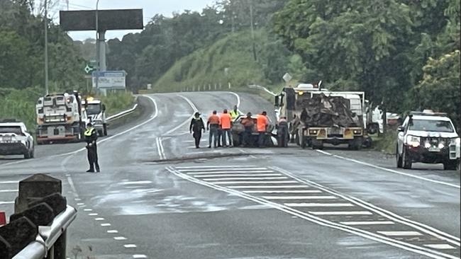 Police and tow truck operators work at the scene of the two-vehicle highway crash that also resulted in a vehicle fire at Glenella. Photo: Fergus Gregg