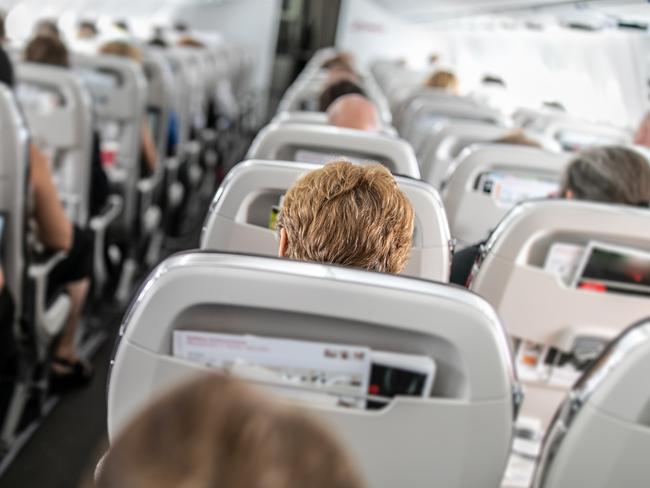 Interior of commercial airplane with passengers in their seats during flight.