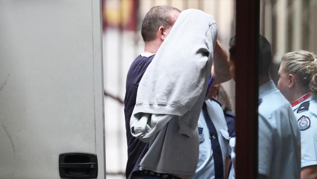 Murdoch covers his face as he is taken into court. Picture: AAP