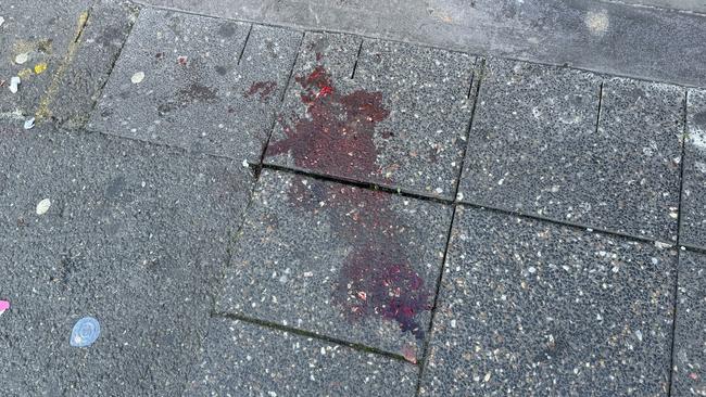 Blood on the footpath at the scene of the assault on Sunday morning. Picture: Dean Martin