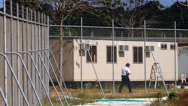 A guard patrols the perimeter fence of the Christmas Island detention centre in 2003. Picture: AAP/File