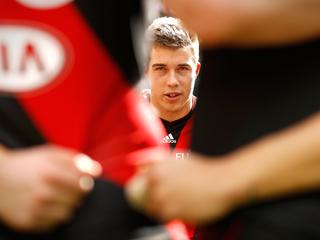 MELBOURNE, AUSTRALIA - AUGUST 14: Acting captain Zach Merrett of the Bombers addresses his teammates during the 2016 AFL Round 21 match between the Essendon Bombers and the Gold Coast Suns at Etihad Stadium on August 14, 2016 in Melbourne, Australia. (Photo by Adam Trafford/AFL Media/Getty Images)
