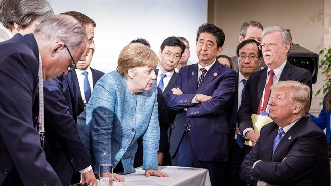 US President Donald Trump talks with German Chancellor Angela Merkel surrounded by other G7 leaders during a meeting of the G7 Summit in La Malbaie, Quebec, Canada, last year.