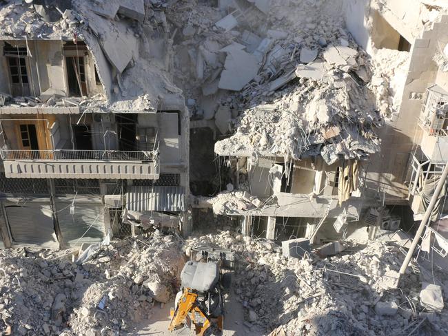 A tractor clears the rubble following Syrian govermnet forces airstrikes in the rebel held neighborhood of Tariq a-Bab in Aleppo on September 24, 2016. Residents in Syria's battleground city of Aleppo cowered indoors as fierce air strikes toppled buildings and killed at least 52 civilians, after diplomatic efforts to revive a ceasefire failed. / AFP PHOTO / THAER MOHAMMED
