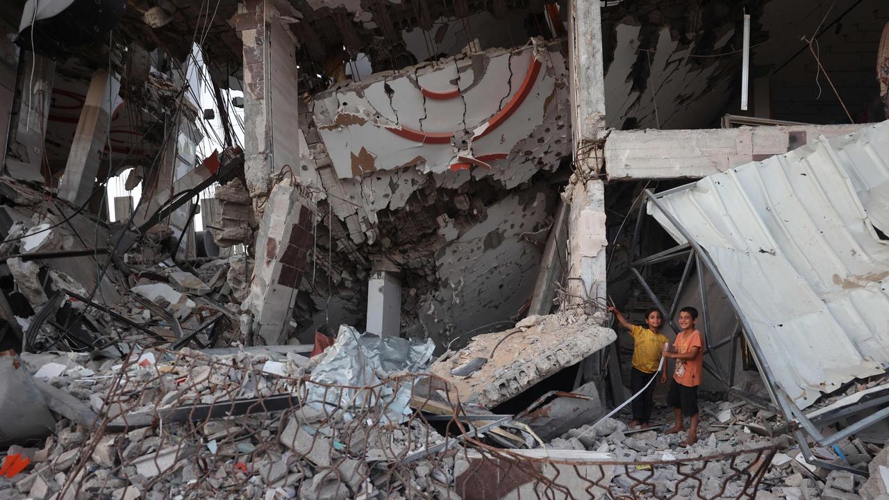 Children play on the rubble of a destroyed building at al-Bureij refugee camp as thousands more remain missing. Picture: AFP