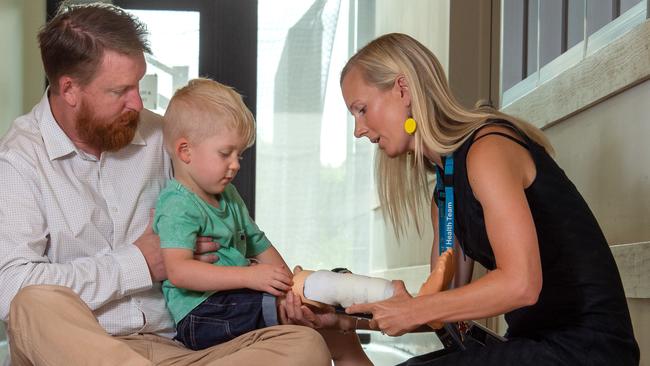 Dad, Andrew watches as prosthetist Phoebe Thompson fits Ollie’s leg and blade. 