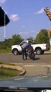 Biker pushes police into traffic