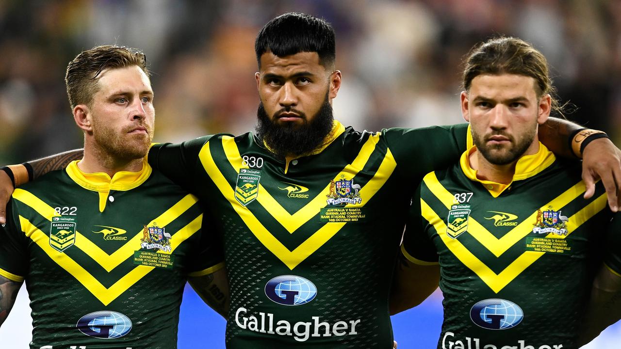 TOWNSVILLE, AUSTRALIA - OCTOBER 14: James Tedesco, Payne Haas and Patrick Carrigan of the Kangaroos stand for the national anthem before the Mens Pacific Championship match between Australia Kangaroos and Samoa at Queensland Country Bank Stadium on October 14, 2023 in Townsville, Australia. (Photo by Ian Hitchcock/Getty Images)