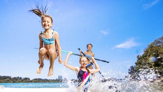 Taylor Gifford, Kiara Pitman and Madison Bell from Ipswich keep cool on their stand up paddle board at Currumbin Creek. Picture: NIGEL HALLETT