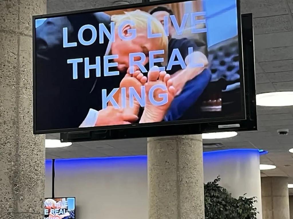 Video screens at the headquarters of a federal department showed an image of President Trump kissing Elon Musk’s two left feet. Picture: Supplied