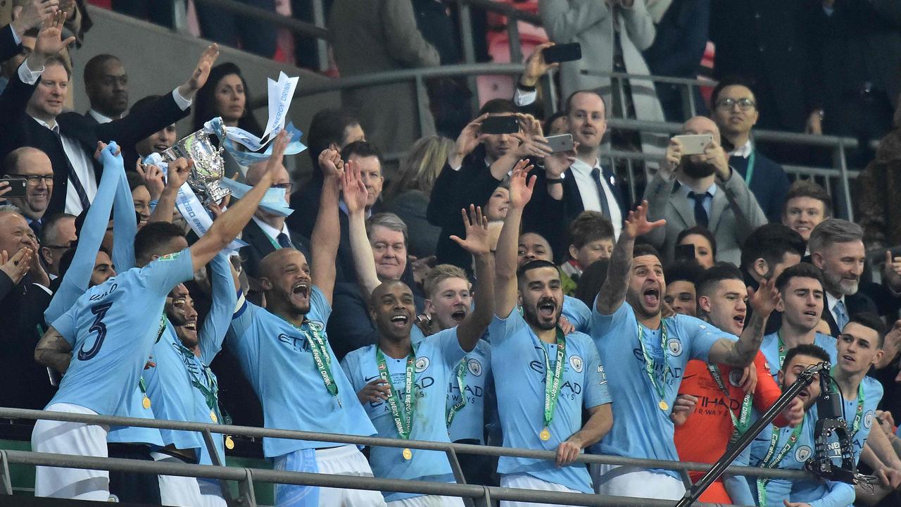 Manchester City's Belgian defender Vincent Kompany (3L) lifts the Cup