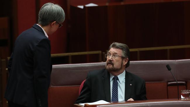 Senator Penny Wong talks to Senator Derryn Hinch in the Senate Chamber. Picture: Kym Smith