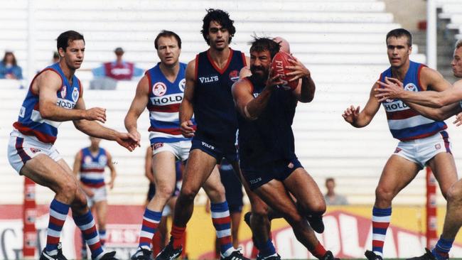 Norwood’s Garry McIntosh grabs possession in front of teammate Lachlan Bowman and Central District opponent Scott Lee in a 1996 SANFL clash.