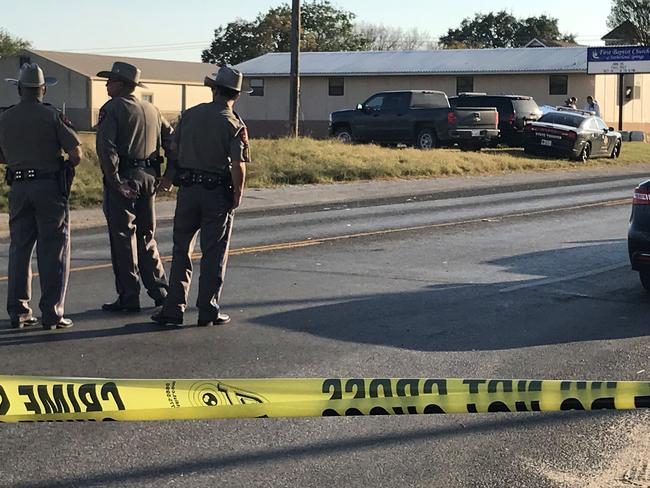 Police block a road in Sutherland Springs, Texas, on November 5, 2017, after a mass shooting at the First Baptist Church (rear). Picture: AFP.