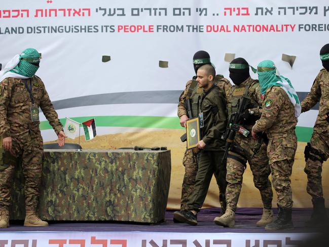 Israeli hostage Omer Wenker is flanked by gunmen in the hostage release ceremony. Picture: AFP