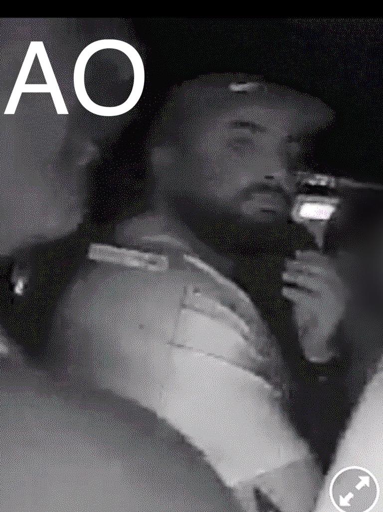 Person AO is described as being a man of Mediterranean/Middle Eastern appearance, solid build, with a dark beard and a star tattoo on his right arm. He is shown wearing a light-coloured shirt with dark writing on the back, shorts and a cap. Picture: Supplied / NSW Police