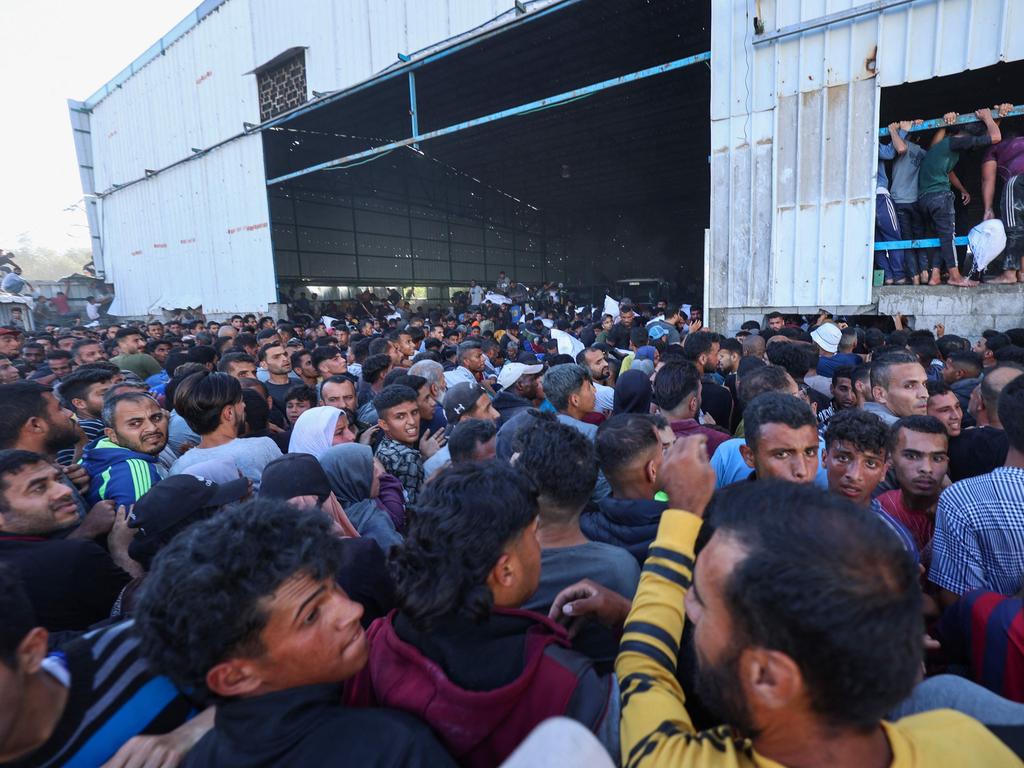 Thousands surround the warehouse in Deir el-Balah. Picture: AFP