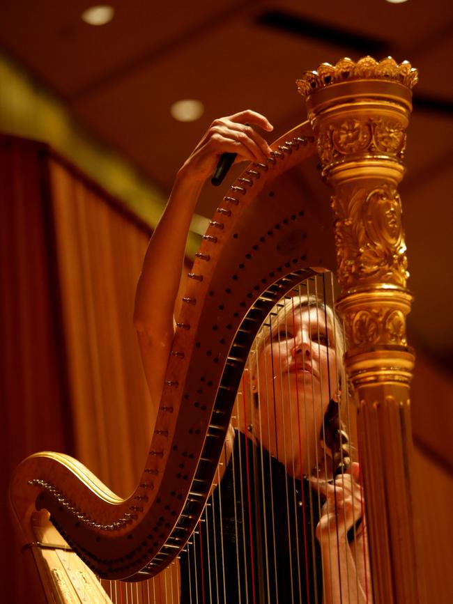 Harpist Louise Johnson tunes up before a concert.