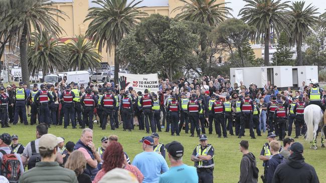 Police hold back crowds of protesters at St Kilda Beach. Picture: Wayne Taylor