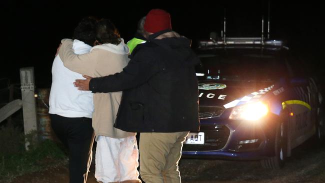 Family comfort each other at the Hillier property on Monday night. Picture: Stephen Laffer