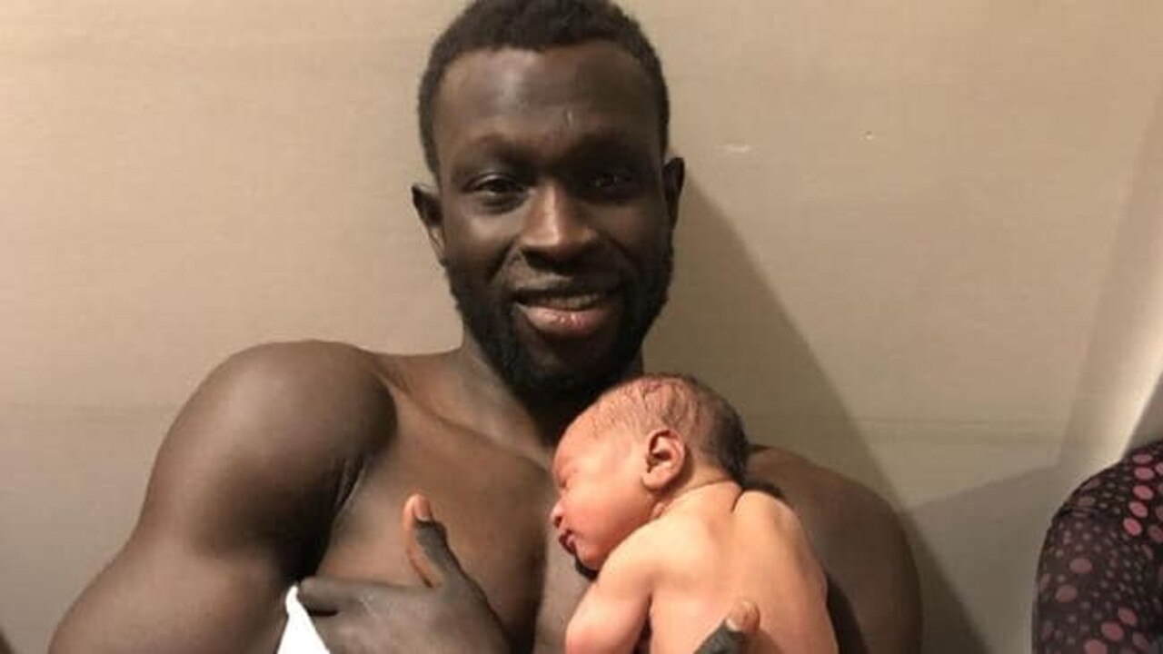 Majak Daw hold his newborn son on Thursday.