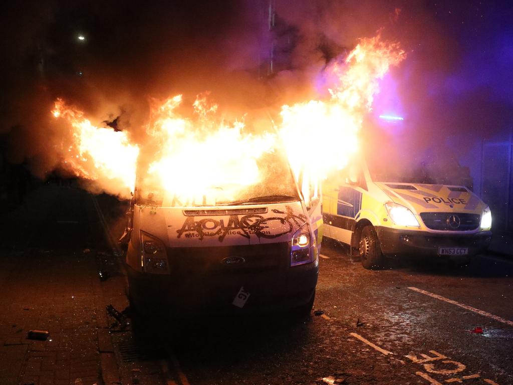 The two police vehicles set on fire. Picture: Andrew Matthews/PA Wire /AAP