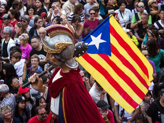 A giant or capgross holding and independence flag, is carried in the middle of a crowd in Sant Jaume square in Barcelona, Spain, Sunday, Sept. 24, 2017. Grassroots groups driving Catalonia's independence movement say they have started distributing one million ballots to be used in a referendum on secession that the Spanish government has vowed to stop. (AP Photo/Emilio Morenatti)