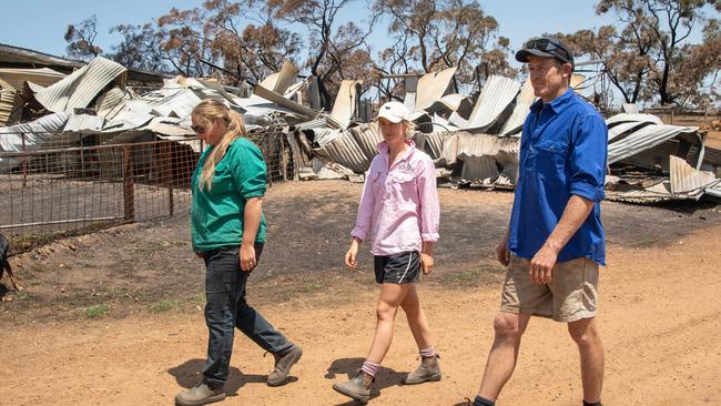 Danielle Short, Lilly Buick and Josh Graham walk around their gutted property. Picture: Brad Fleet