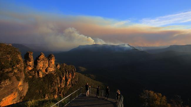 The Three Sisters rock formation to the left and smoke from the Green Wattle Creek fire in the distance. Picture: AAP/Steven Saphore