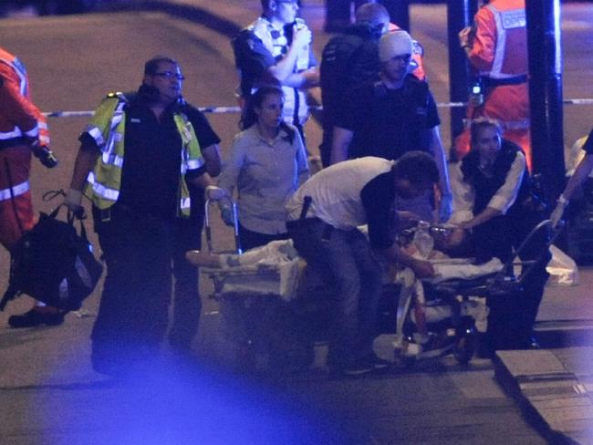 Police officers and members of the emergency services attend to an injured person. Picture: AFP / Daniel Sorabji