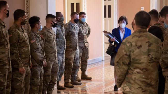 National Guards inside the Capitol watch as Republican senator Susan Collins walks to the third day of Donald Trump’s impeachment trial. Picture: AFP