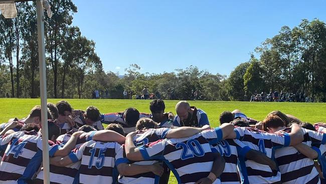 John Paul College First XV rugby team in a huddle on Saturday afternoon.