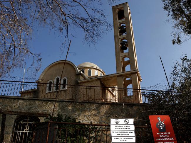A deserted Christian orthodox church is seen behind a military sign in Varosha. Picture: Petros Karadjias.