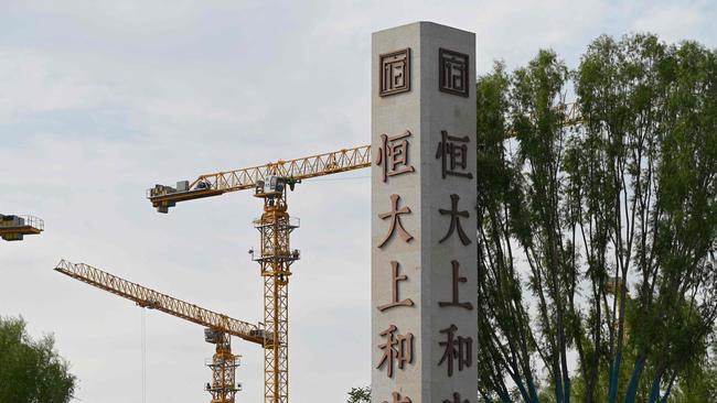 The Evergrande name and logo are seen outside the construction site of an Evergrande housing complex in Beijing on September 13, 2021. (Photo by GREG BAKER / AFP)