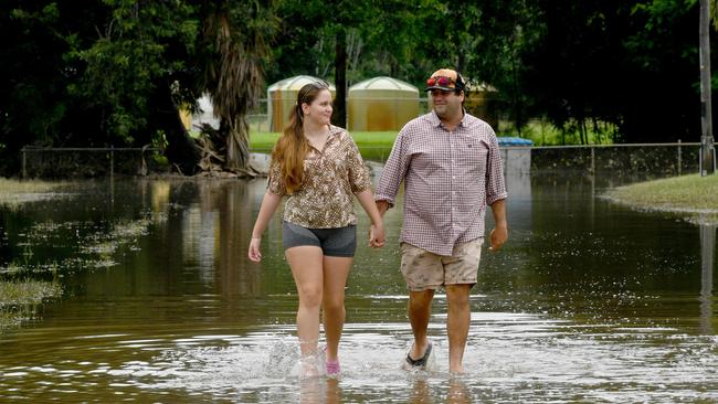 Mahala Thorn and Ryan Maustoukas walk through flooded Brooke Street in Giru on Sunday. Picture: Evan Morgan